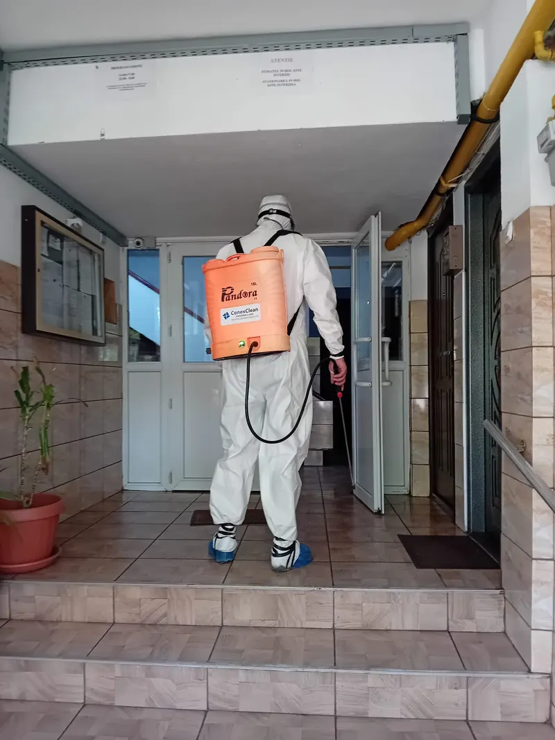 Operator DDD în echipament de protecție la intrarea unui bloc